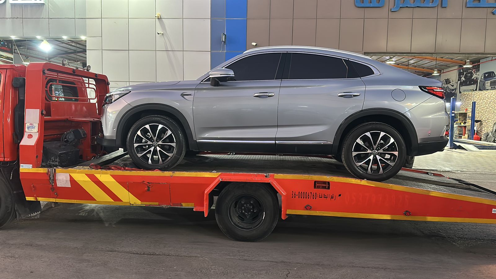 Flatbed tow truck loading a passenger vehicle